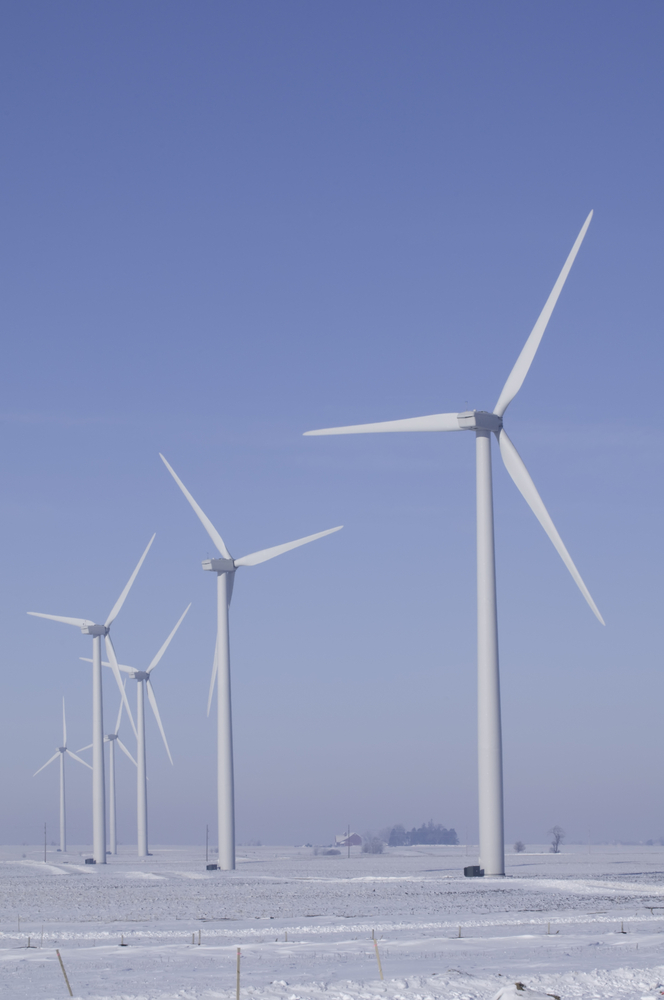 Wind turbines stand above wintry farmland in northern Illinois (roadside view)